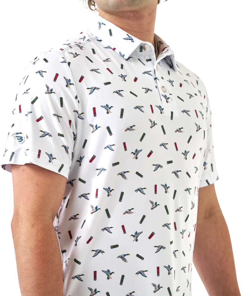 Man wearing a white polo shirt with small colorful ducks and shotgun shells patterns on a white background
