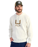 Man wearing a cream hoodie with 'Huk' logo and a cap on a white background