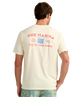 Man wearing a cream HUK t-shirt with red MARINA HUK and graphics on the back, standing against a white background.