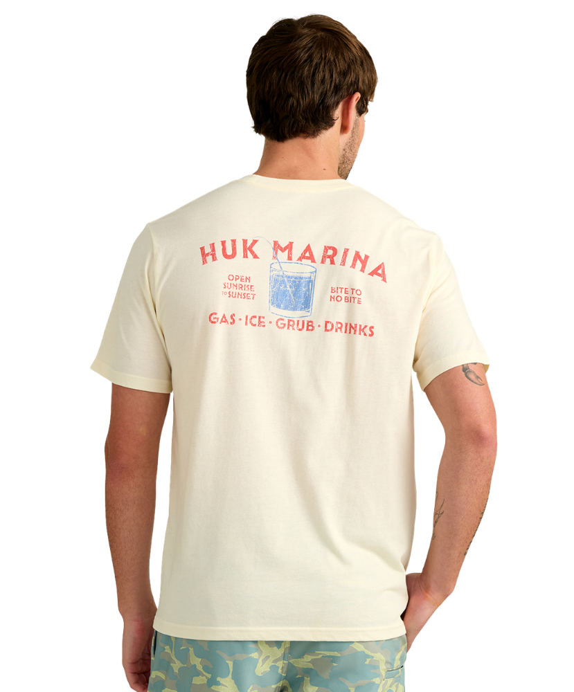 Man wearing a cream HUK t-shirt with red MARINA HUK and graphics on the back, standing against a white background.