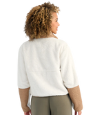 Woman wearing a white and beige fleece pullover on a white background