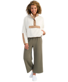 Woman wearing a white and beige fleece pullover on a white background