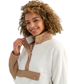 Woman wearing a white and beige fleece pullover on a white background