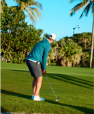 Person playing golf on a sunny day with palm trees in the background