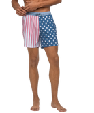 Person wearing American flag patterned swim shorts on a white background
