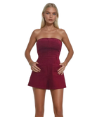 Woman wearing a strapless burgundy GARNET romper on a white background