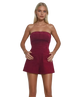 Woman wearing a strapless burgundy GARNET romper on a white background