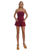 Woman wearing a strapless burgundy GARNET ROMPER WITH POCKETS on a white background