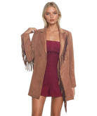 Woman wearing a brown suede jacket with fringe details OVER A BURGUNDY GARNET ROMPER on a white background