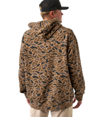 Person wearing a camouflage hoodie jacket and cap on a white background