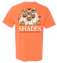Orange t-shirt with Halloween-themed design of dogs in ghost costumes and pumpkins, featuring the brand 'SHADES'.