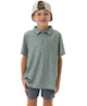 A young boy wearing a gray and blue PRINTED polo shirt with a collar, short sleeves, and light-colored shorts, smiling and posing for the camera.