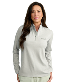 Woman wearing a gray Huk pullover on a white background