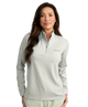 Woman wearing a gray Huk pullover on a white background