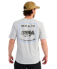 Man wearing a gray t-shirt with Huk & Co fishing supplies logo on the back, Bass graphic, standing against a white background.