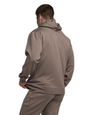 Man wearing a brown hoodie and joggers on a white background