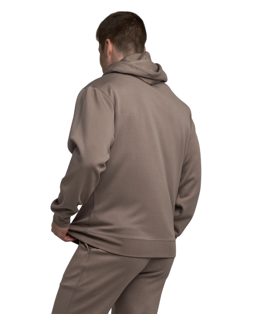 Man wearing a brown hoodie and joggers on a white background