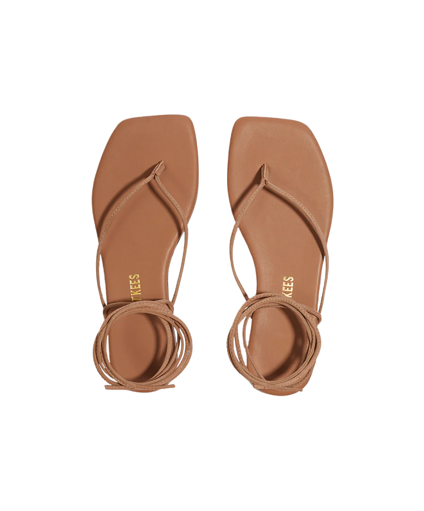Pair of brown sandals with ankle straps on a white background