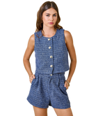 Woman wearing a blue sleeveless top and shorts set on a white background