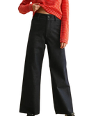 Person wearing black wide-leg pants with a red and white striped shirt.