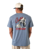 Man wearing a blue t-shirt with 'Burlebo Outdoors' graphic on the back, standing against a white background.