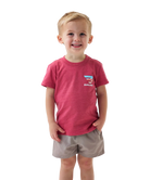 Child wearing a red t-shirt with a logo on a white background