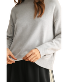 Person wearing a gray sweater with a white background