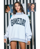 Woman wearing a heather grey sweatshirt with 'GAMEDAY' printed on it against a white background