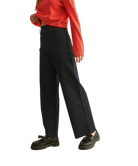 Person wearing a red striped shirt and black pants on a white background
