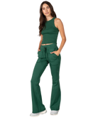 Woman wearing a green tank and pants athleisure set outfit on a white background