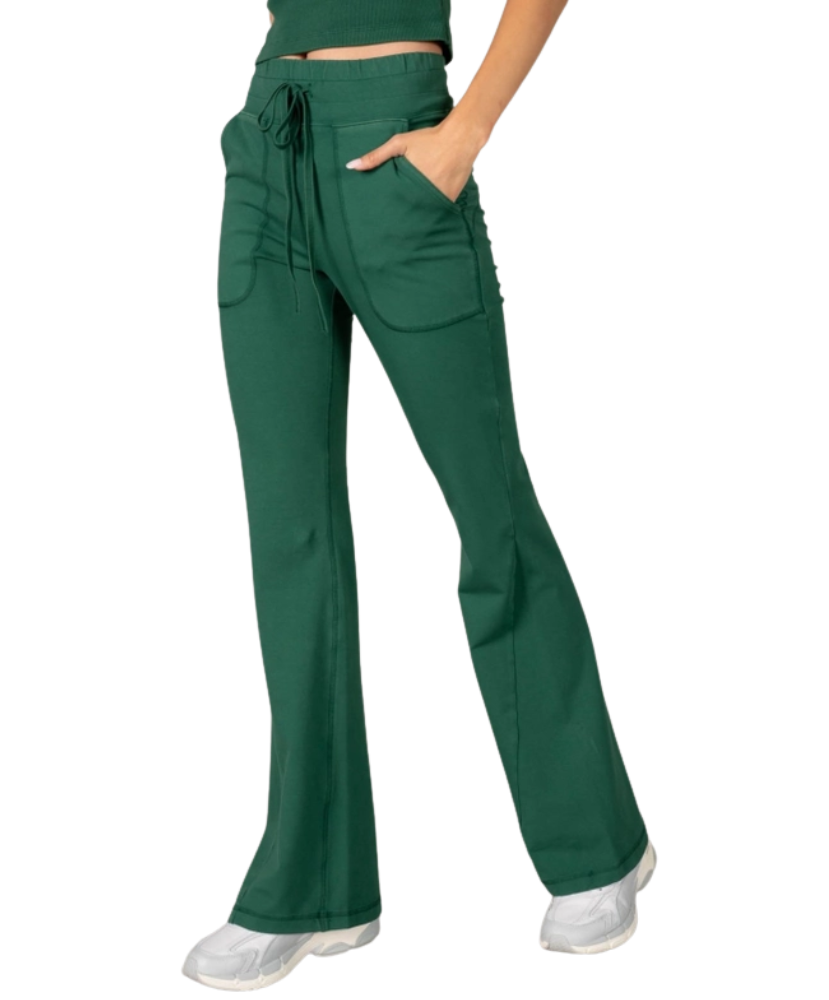 Woman wearing a green tank and pants athleisure set outfit on a white background