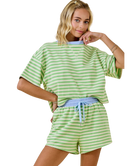 Woman wearing a green and white striped outfit on a white background