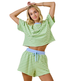 Woman wearing a green and white striped outfit on a white background