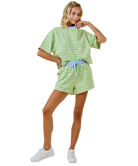 Woman wearing a green and white striped outfit on a white background