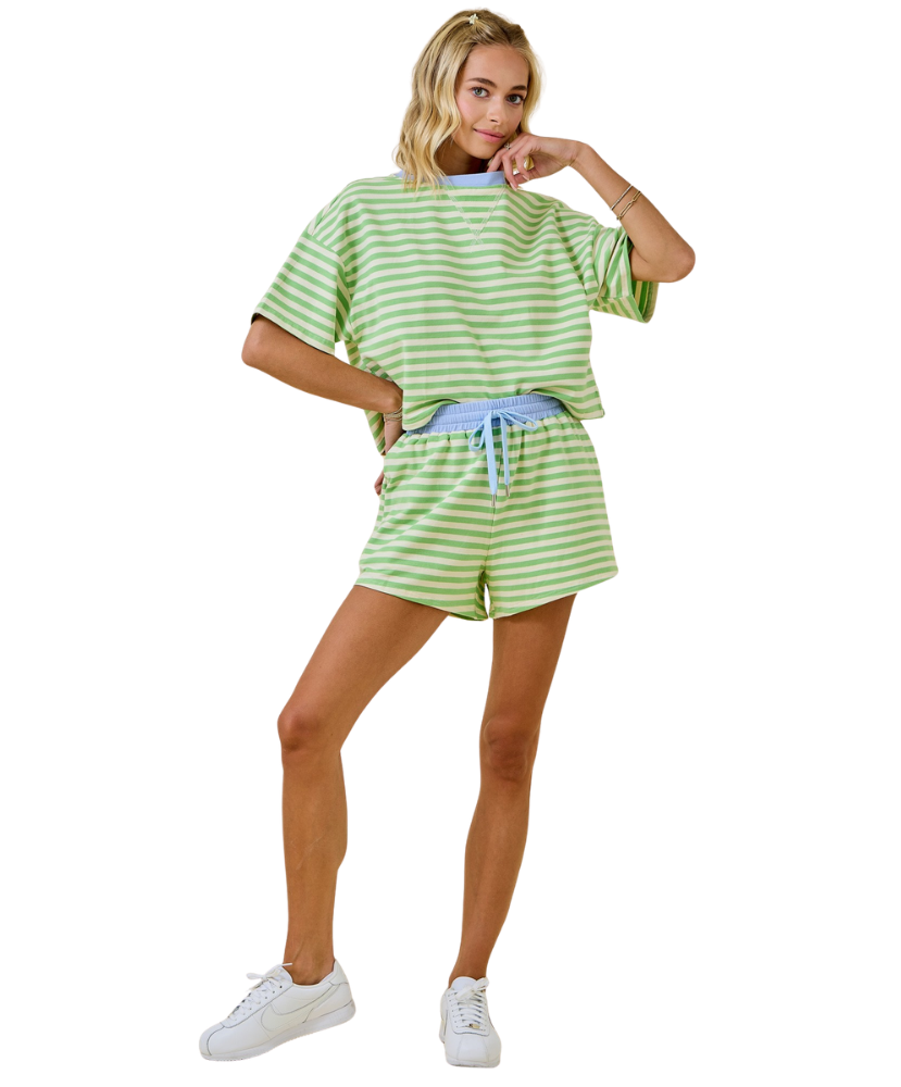 Woman wearing a green and white striped outfit on a white background