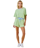 Woman wearing a green and white striped outfit on a white background