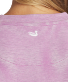 Close-up of a purple striped shirt with a small white logo on the chest.