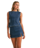 Woman wearing a denim sleeveless top and skirt on a white background