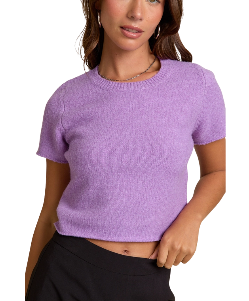 Woman wearing a purple knit top against a white background