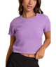 Woman wearing a purple knit top against a white background