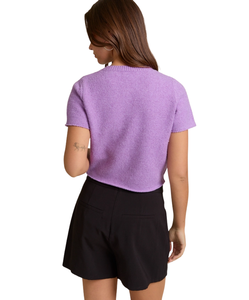 Person wearing a purple top and black shorts on a white background