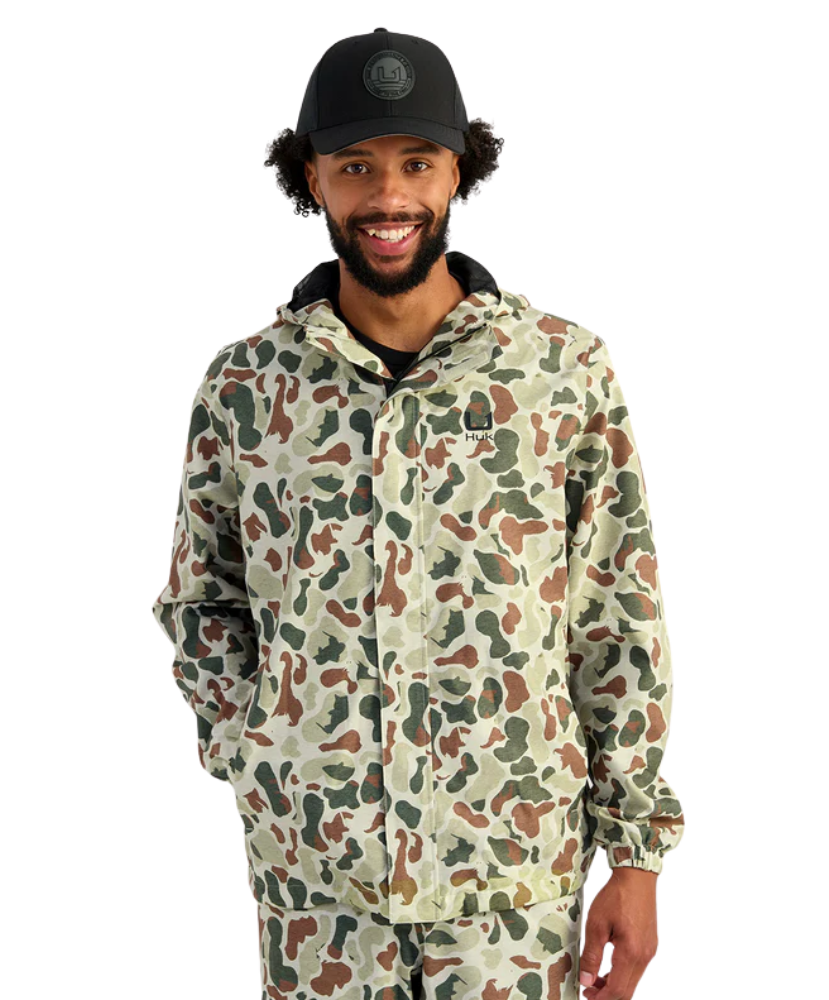 Man wearing a camouflage jacket and cap on a white background