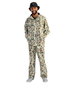 Man wearing a camouflage HUK jacket and hat on a white background