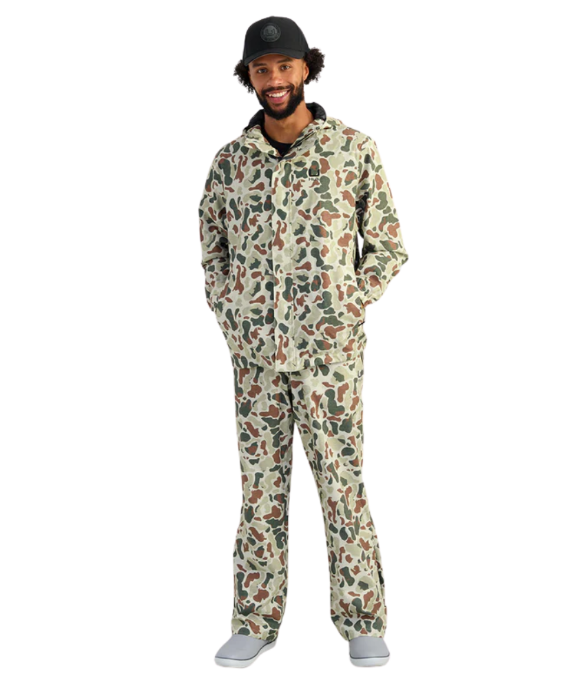 Man wearing a camouflage HUK jacket and hat on a white background