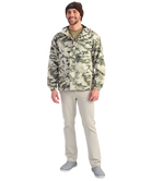 Man wearing a camouflage HUK jacket and beanie on a white background