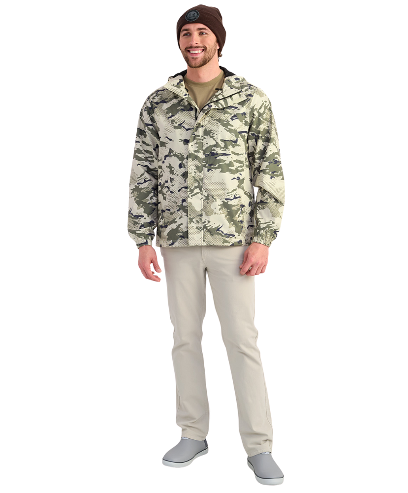 Man wearing a camouflage HUK jacket and beanie on a white background