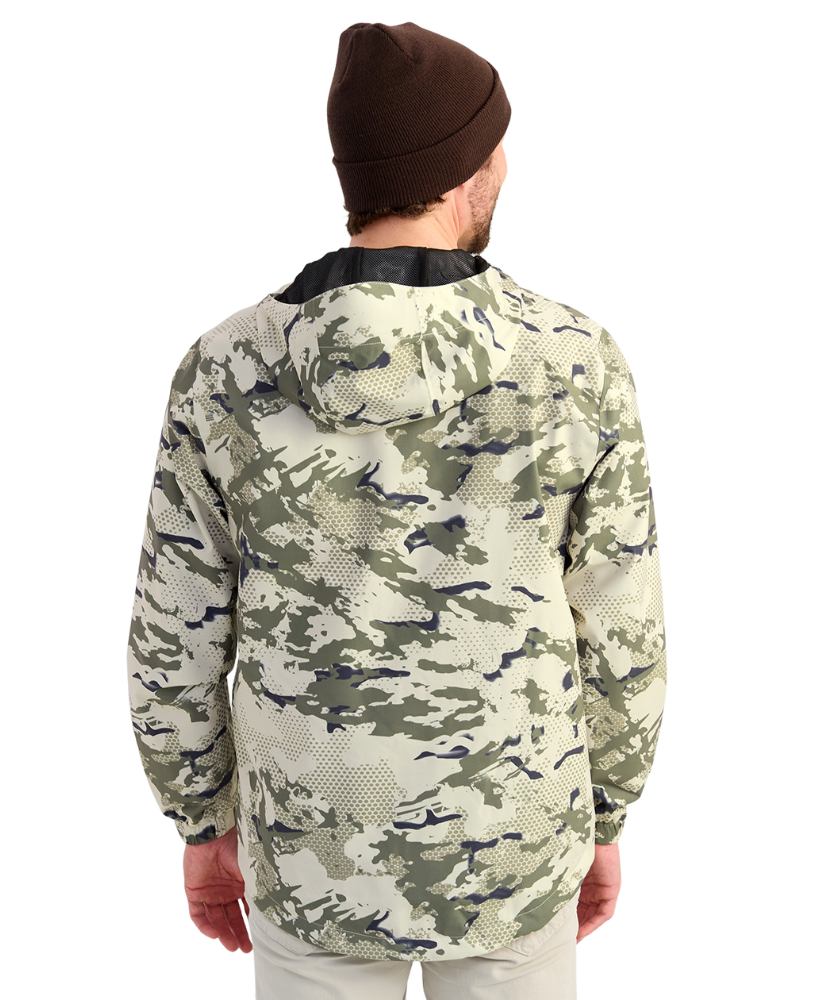Man wearing a camouflage HUK jacket and beanie on a white background