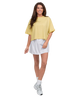 Woman wearing a yellow top and white skirt on a white background