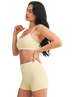 Woman wearing a yellow sports bra and shorts set on a white background