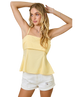 Woman wearing a yellow top and white shorts on a white background